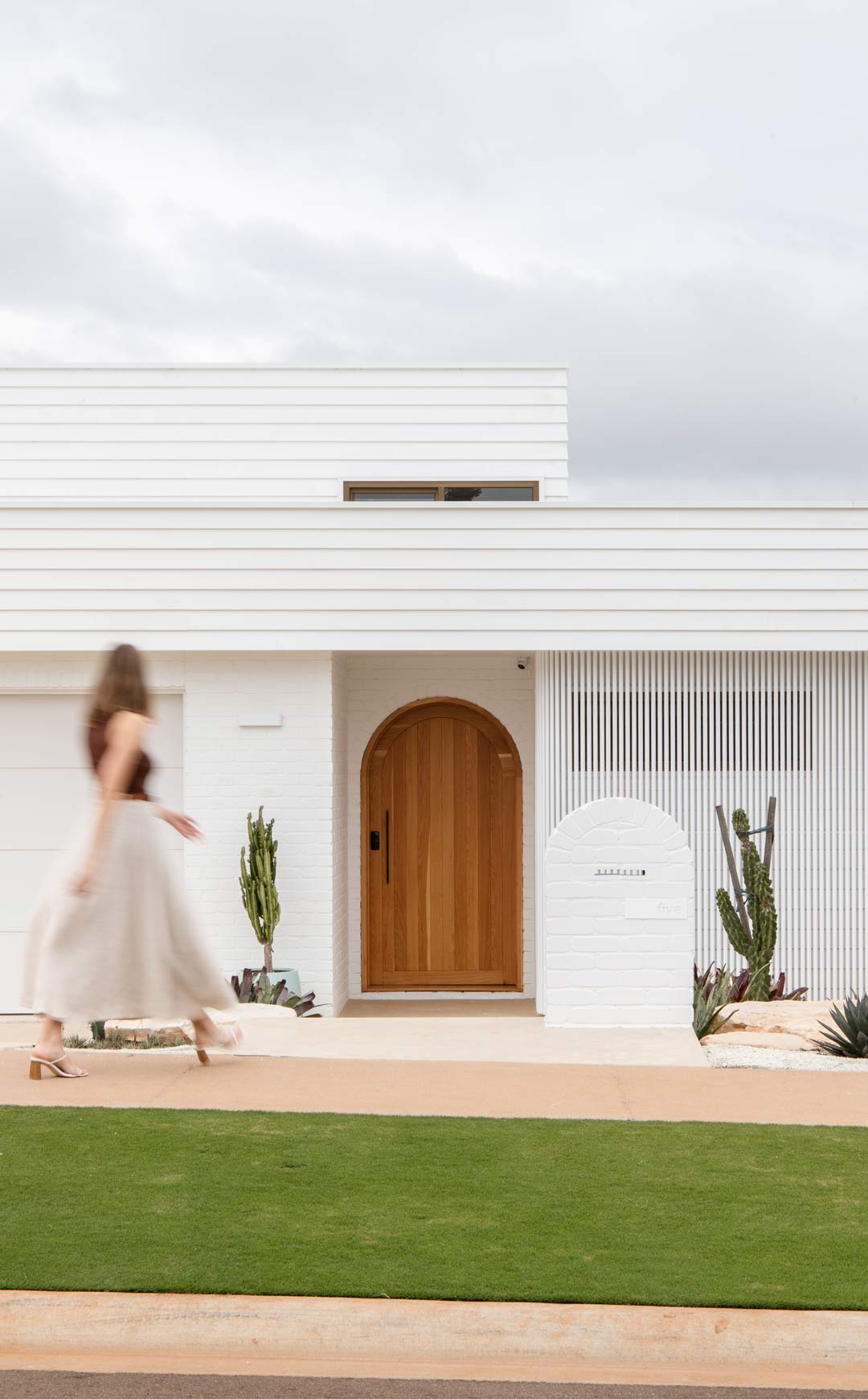 Palm-Springs-inspired-house-front-facarde-with-an-arched-timber-door-and-cactus-plants