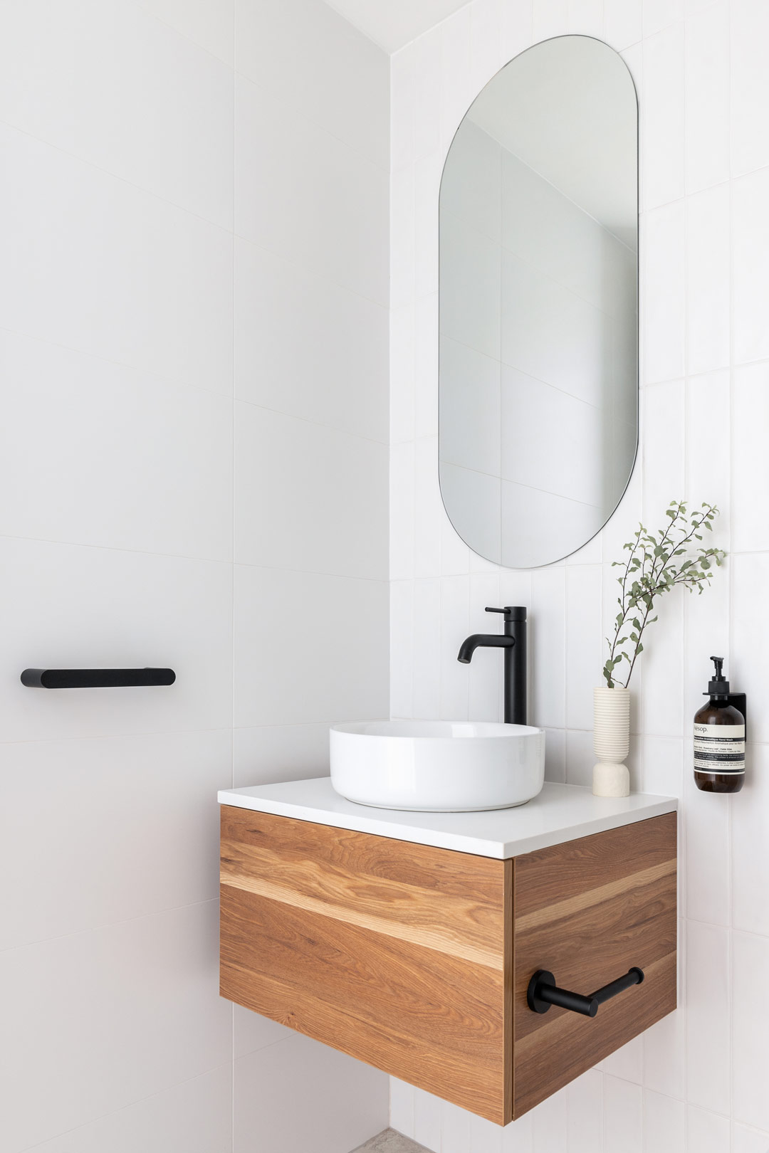 Simple-coastal-bathroom-design-with-matte-black-fixtures-white-soft-tiles-and-natural-timber-vanity-2